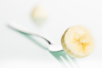 Close up of banana slice on fork.