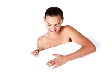 Obraz premium Beautiful girl with perfect skin holding blank board.