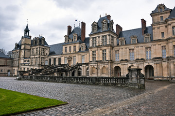 Fototapeta na wymiar Entrance to the Chateau de Fontainebleau on a rainy day, France