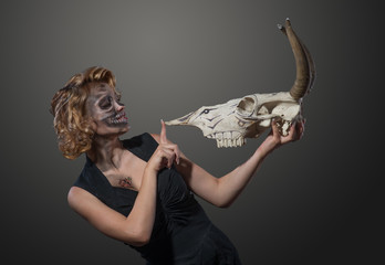 Woman with cow's skull in her hands, face to face