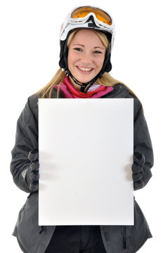 Junge Frau in Skianzug h&auml;lt leeres Schild