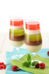 fruit jelly in glasses, berries and mint on wooden table