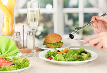 Female hand with  dinner on bright background