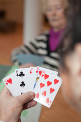 Ältere Dame spielt Karten
