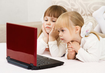 Two little girls are with a laptop and a credit card