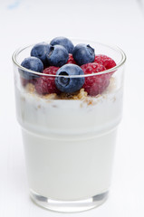 Glass with yogurt and berries close up