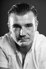 Fototapeta premium Handsome man with short brown hair. Black and white studio.