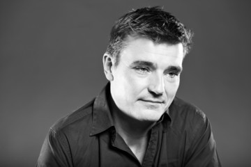 Handsome man with short brown hair. Black and white studio.