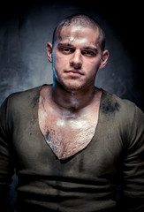 Portrait of muscular young man with dirty face and chest