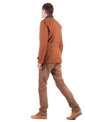 Naklejka premium Back view of walking handsome man in jeans and jacket.