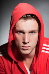 Fashion portrait of urban young man wearing red hoody jacket.