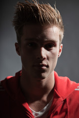 Obraz premium Fashion portrait of sportive young man wearing red jacket.