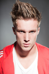 Obraz premium Fashion portrait of sportive young man wearing red jacket.