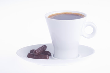 coffee with three chocolates on a saucer on a white background