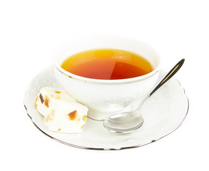Tea cup with sweets on white background