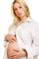 Closeup of a pregnant woman touching her belly with hands