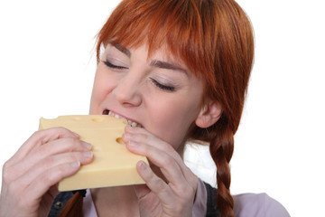 Woman biting into a piece of cheese