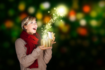junge blonde Frau öffnet Geschenk mit magischem Inhalt