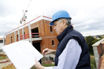 Construction manager checking building project on site