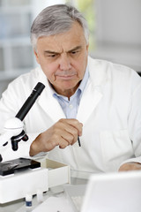 Researcher in lab looking at laptop computer