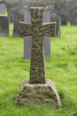A Granite Stone Cross Standing in a Cemetery.