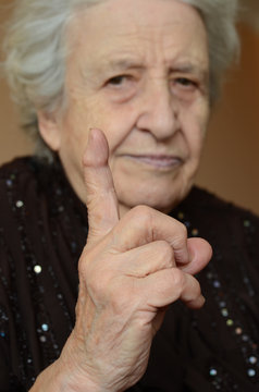 senior woman with her finger up for admonition