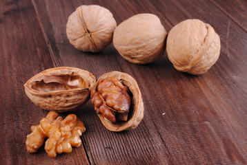 whole and cracked walnuts on a wooden table