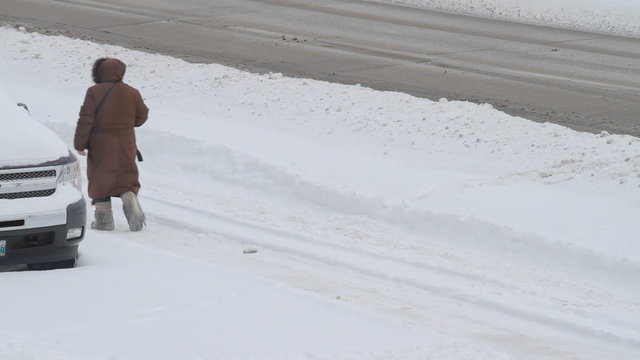 Man moves on a snowy road in winter storm