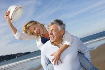 Portrait of cheerful senior couple having fun at the beach - obrazy, fototapety, plakaty