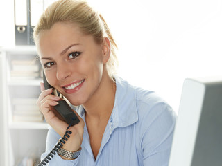 Female office assistant has a call at the office