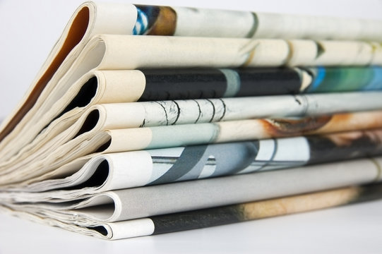 Pile of newspapers over white background