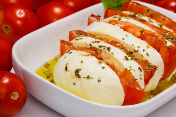 Tomato and mozzarella slices with olive oli and  basil  leaves