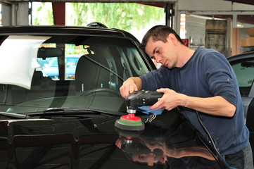 Man polishing a black car bonnet.