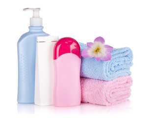 Obraz na płótnie Canvas Shampoo and gel bottles with towels and flower
