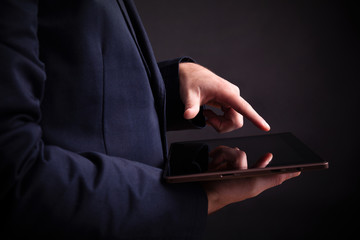 Man holding a digital tablet on black background