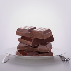 Chocolate bars stack on plate.
