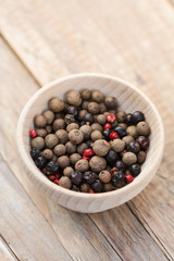 Pimento and juniper berries and pink peppercorns in a bowl