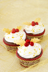 Christmas cupcakes with gold leaves and red berries