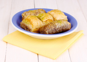 Sweet baklava on plate on wooden background