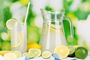 Citrus lemonade in pitcher and glass of citrus around