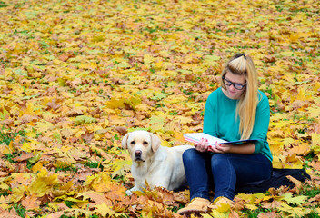 Girl with dog studying in nature