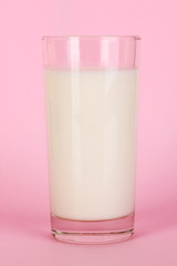 Glass of fresh new milk on pink background
