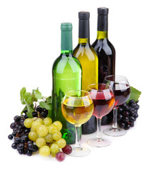 bottles and glasses of wine and assortment of grapes, isolated