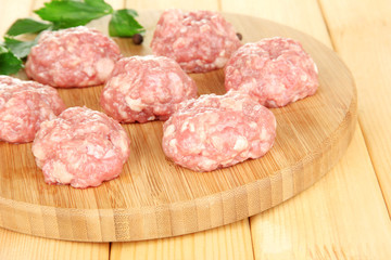 Raw meatballs on wooden table