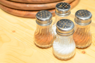 Pizza seasonings on a wood table.