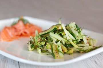 Kohlrabi salad with smoked salmon on background