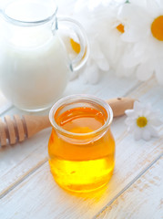 fresh honey in the glass bank and milk in jug