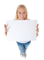 Fototapeta premium Attraktive junge Frau hält weißes Schild