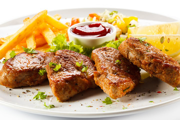 Grilled steaks, French fries and vegetables