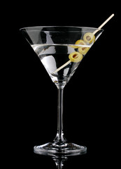 Martini glass and olives isolated on black